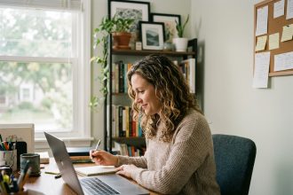 Femme assise à son bureau dans un home office cosy