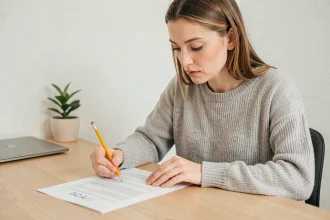 Femme concentrée remplissant un test de QI sérieux sur papier dans un bureau minimaliste à domicile